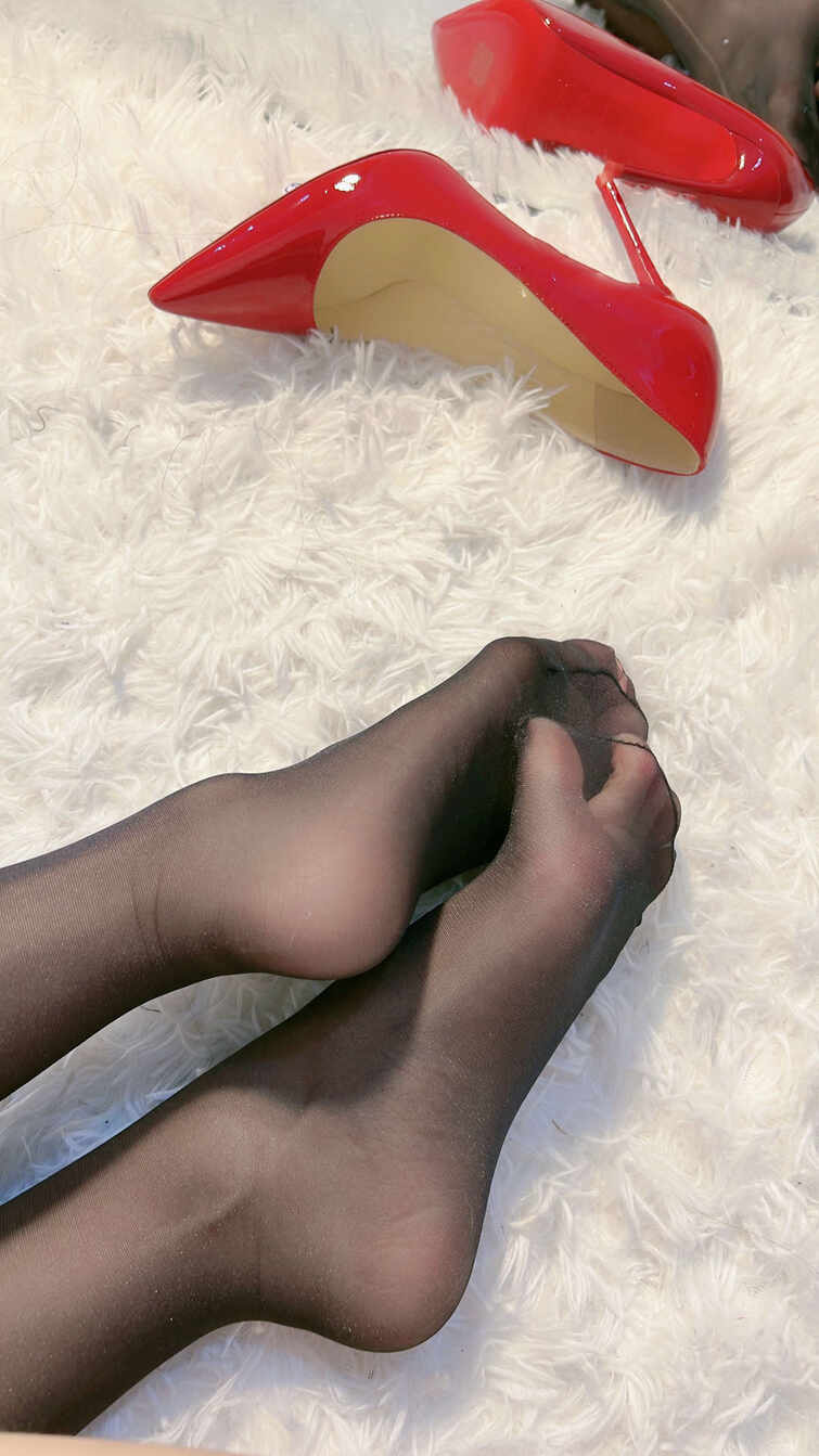 陈佩奇yyyy穿着黑色透明丝袜的双脚，旁边放着一双脱下的红色漆皮尖头细高跟鞋，在白色毛绒地毯上。