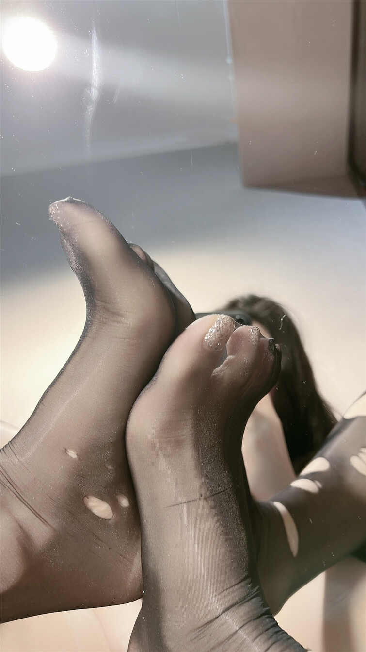 陈佩奇yyyy穿着黑色破洞/抽丝效果透明丝袜的双脚在镜面上反射，特写展示丝袜的破洞细节和光泽感。