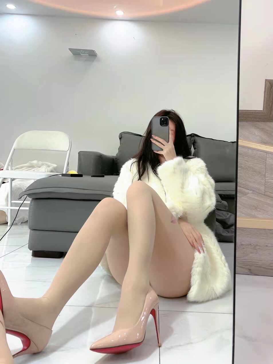 陈大小姐“唇印肤色丝袜暖冬俏皮”VIP写真，身着白色毛绒外套，搭配带唇印图案的肤色丝袜与裸色高跟鞋，坐在地板上通过镜子进行时尚自拍。