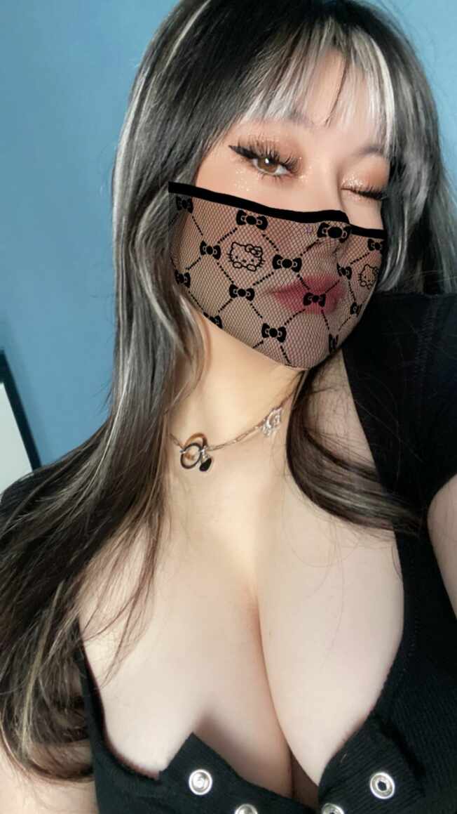 歪歪酱“扎染牛仔蕾丝面罩个性”主题，近距离特写佩戴黑色蕾丝Hello Kitty图案时尚面罩，搭配黑色紧身上衣，展现神秘魅惑风格。