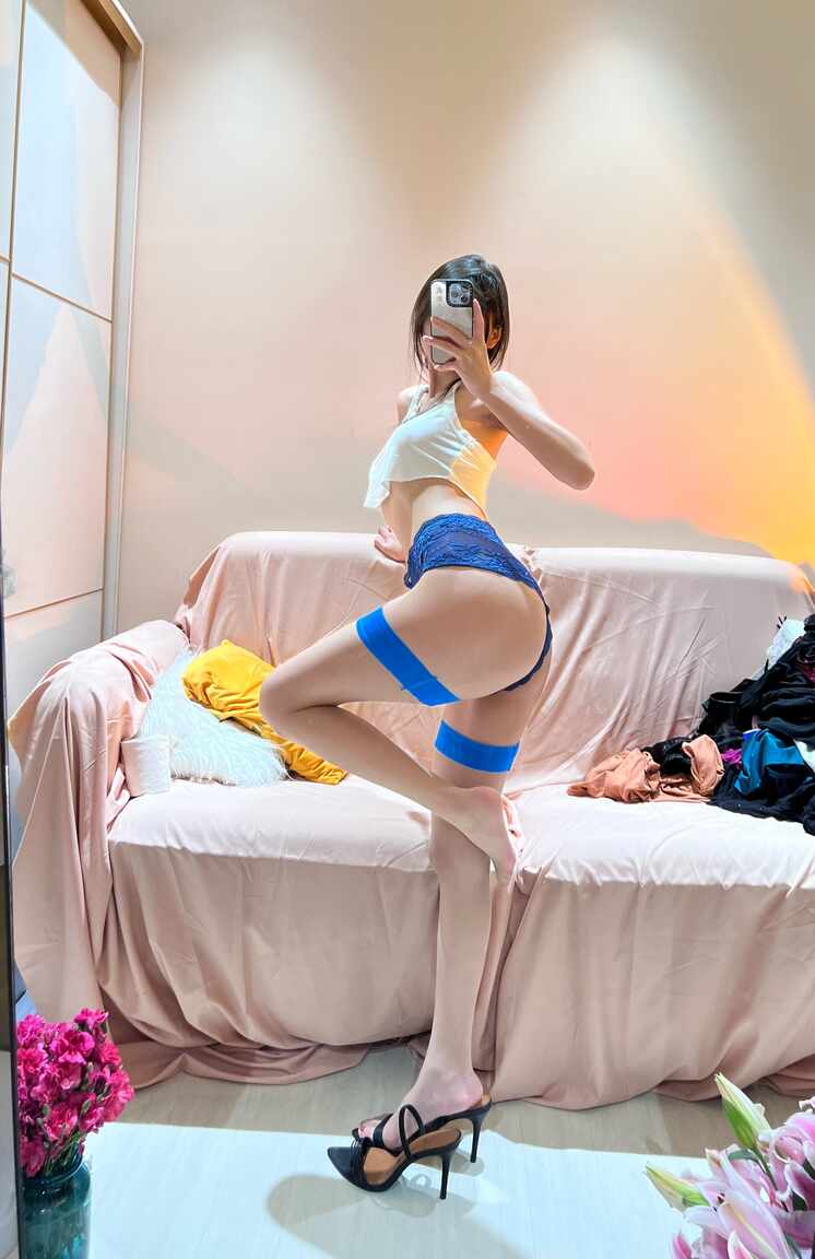  “我就是张包包-蓝白撞色镜前OOTD”主题，模特身着蓝白撞色时尚套装侧身站立，展现修长的腿部线条与白色丝袜、蓝色腿环的搭配细节。